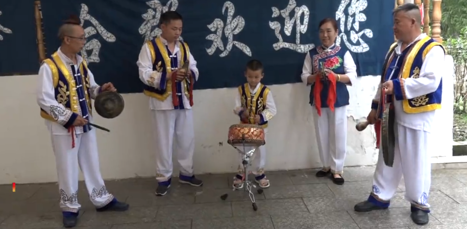 6岁小孩能掌鼓,大人围着小孩鼓点敲打乐器
